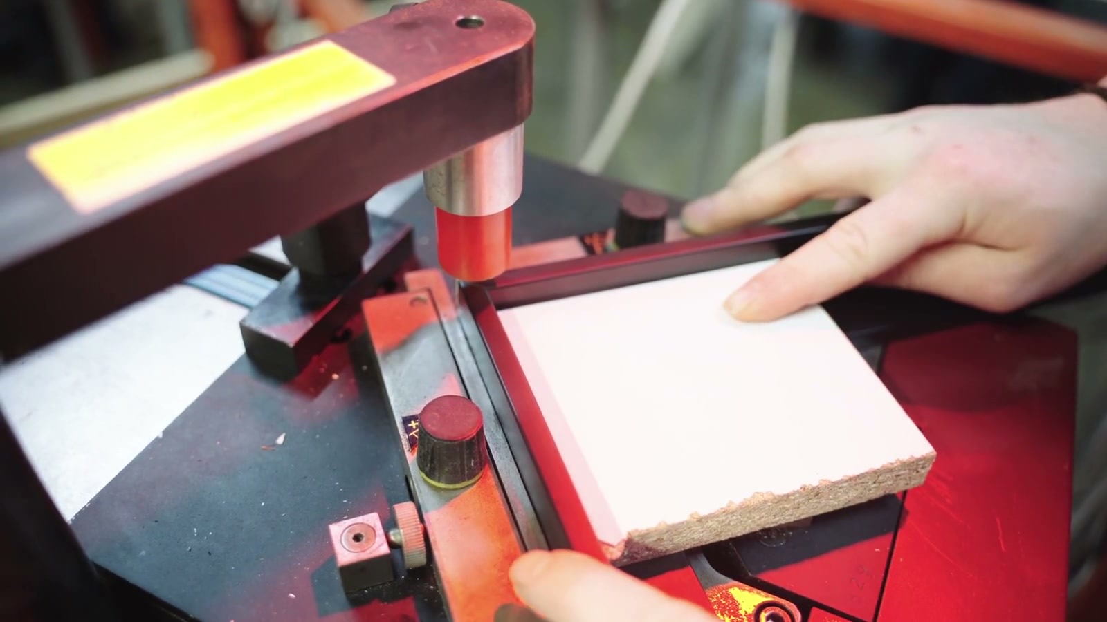 Mains d’encadreur positionnant un panneau sur une machine d’atelier